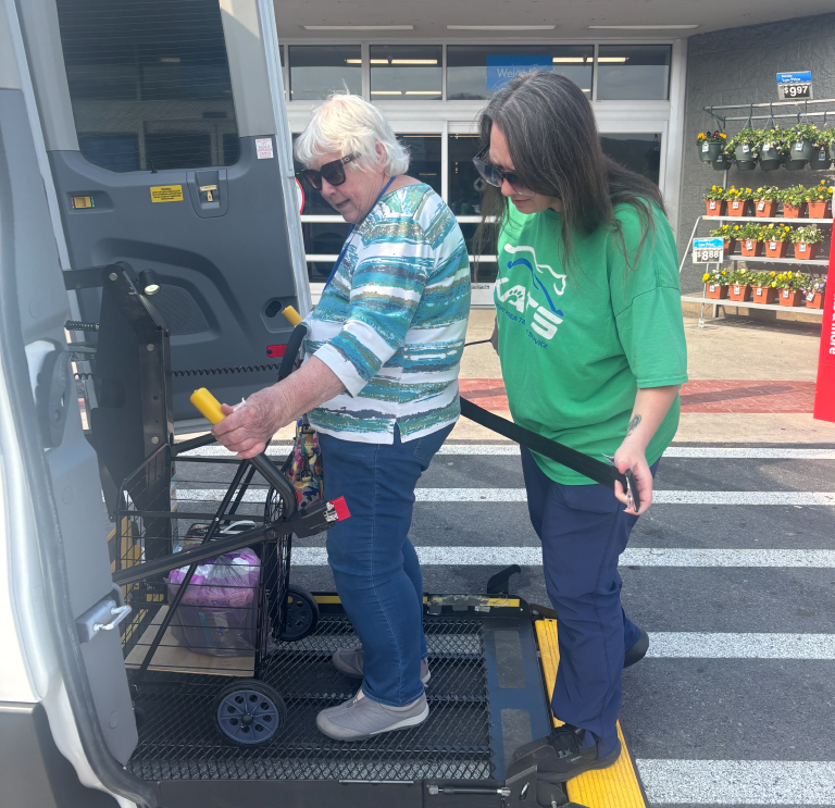 a man and a woman loading luggage onto a bus